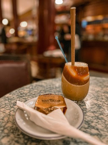 Doce embalado do Café Tortoni com um copo de café gelado