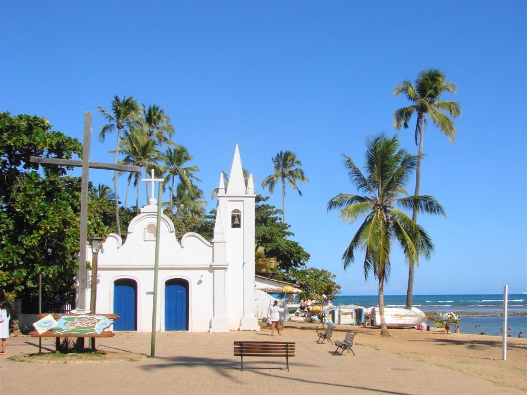 Capela Praia do Forte com coqueiros no entorno