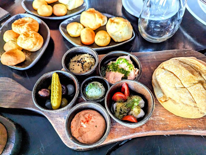 Mesa posta com opções de pães e legumes