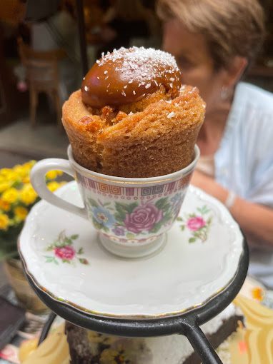 Doce servido em uma xícara branca com flores