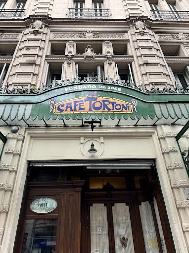 Fachada do Café Tortoni, com nome escrito em uma placa verde com amarelo e azul.