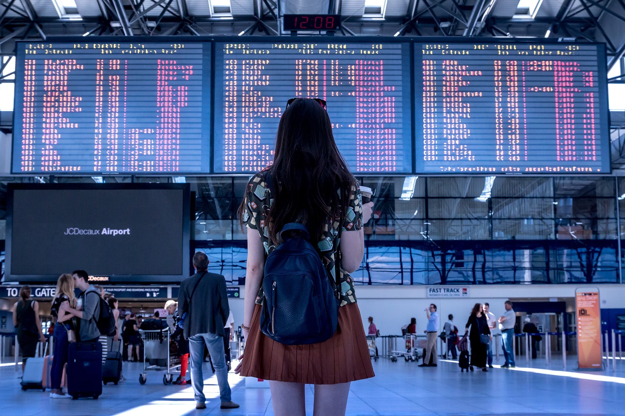 Mulher olhando painel de voos em aeroporto