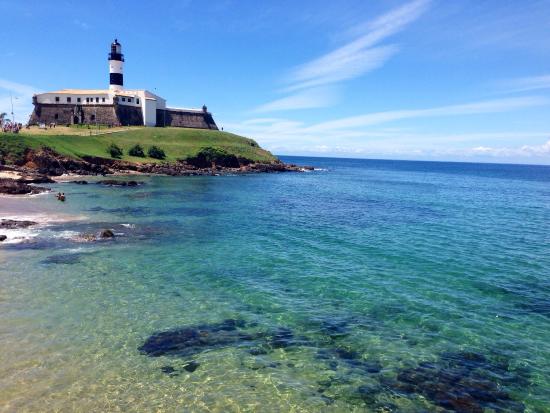 Praia Farol da Barra com mar cristalino em tom de azul claro