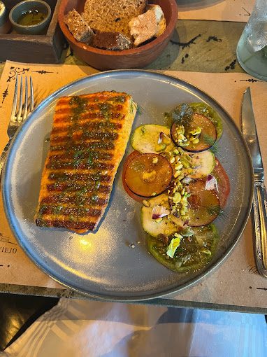 Prato de comida com peixe grelhado e legumes ao lado.