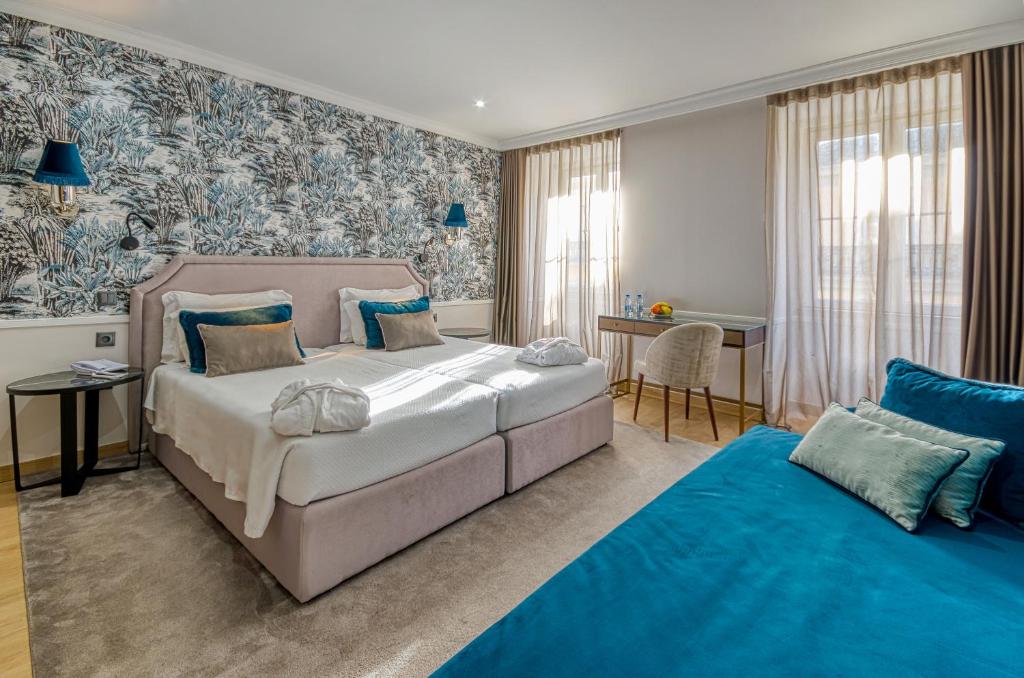 Quarto com cama de casal, escrivaninha, cadeira e decoração do Hotel Borges Chiado - Lisboa - Portugal