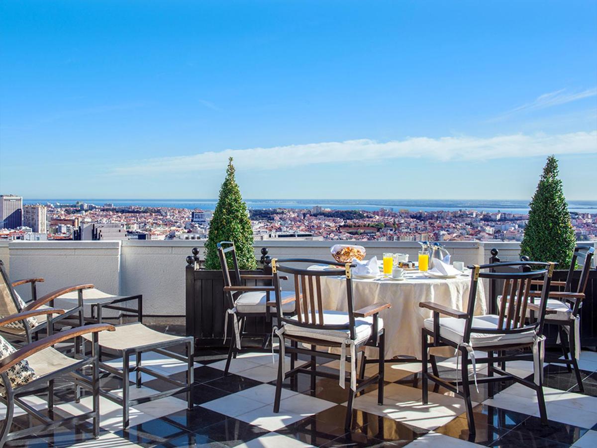 Terraço com mesas, cadeiras, planta, suco de laranja em compos. Hotel Dom Pedro Lisboa - Lisboa, Portugal