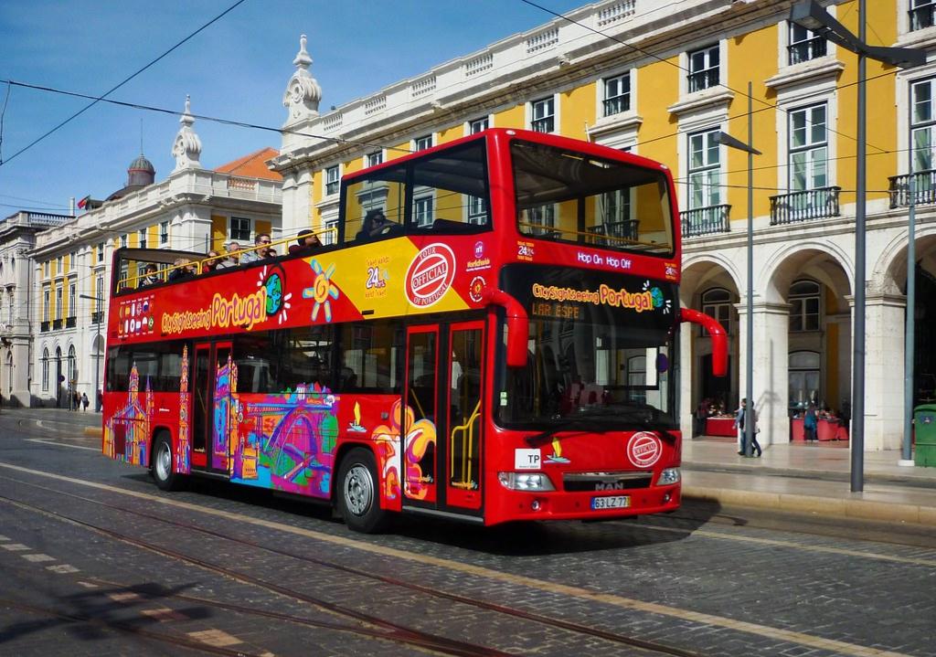 Ônibus turístico passando pela rua em Lisboa, Portugal