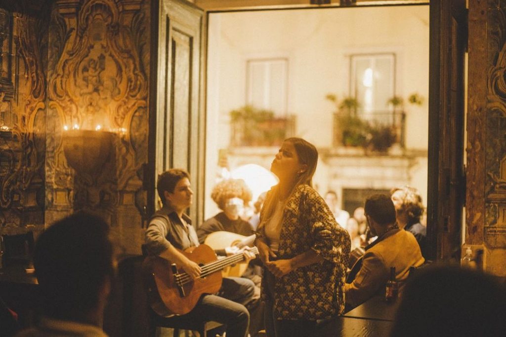 Imagem de uma mulher cantando em uma casa de fado em Lisboa, Portugal