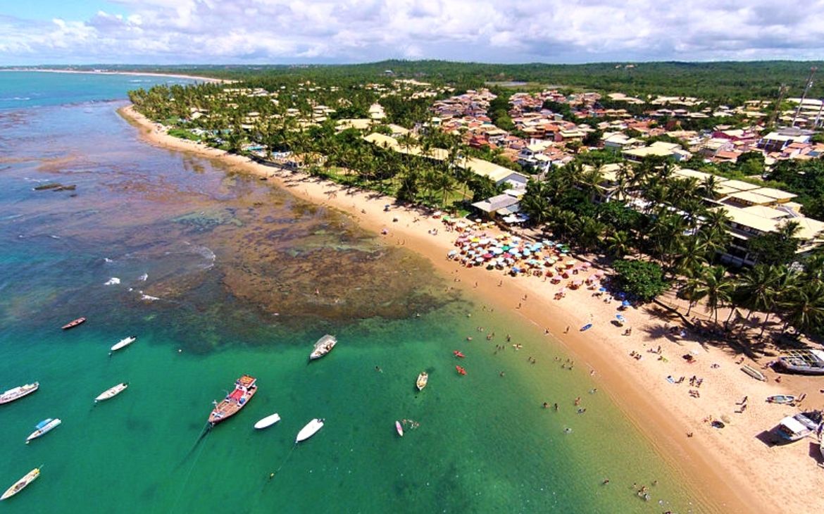 Vista aérea da Praia do Forte com água cristalina e recife de corais