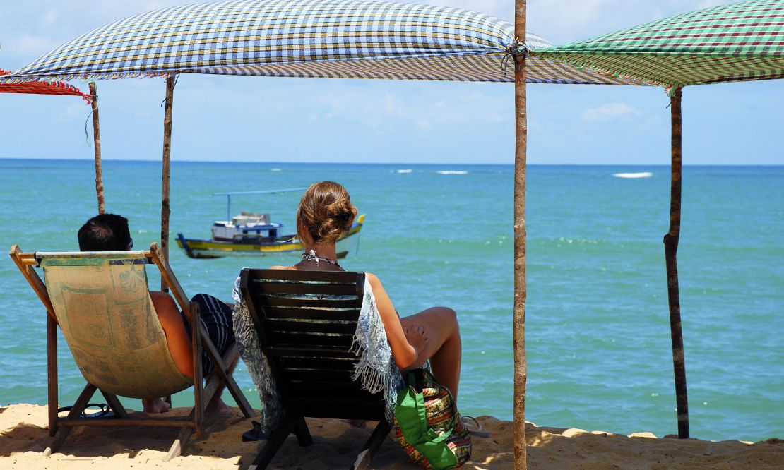 Família sentada na beira da praia