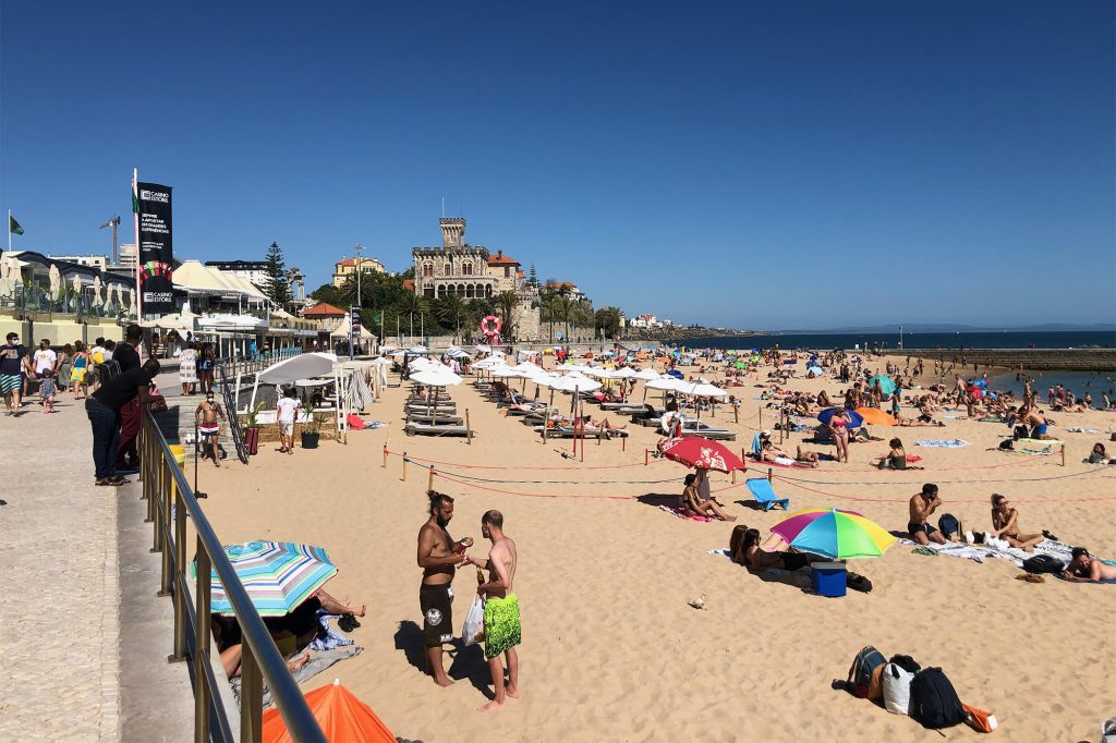 Pessoas na areia da Praia em Lisboa, Portugal - Foto: Descubra Portugal