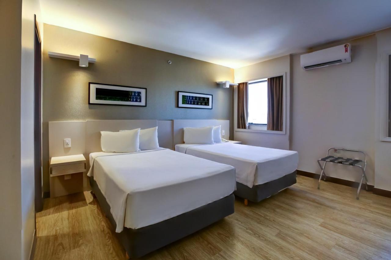 Quarto com duas camas, janela e ar condicionado do Comfort Suites Brasília