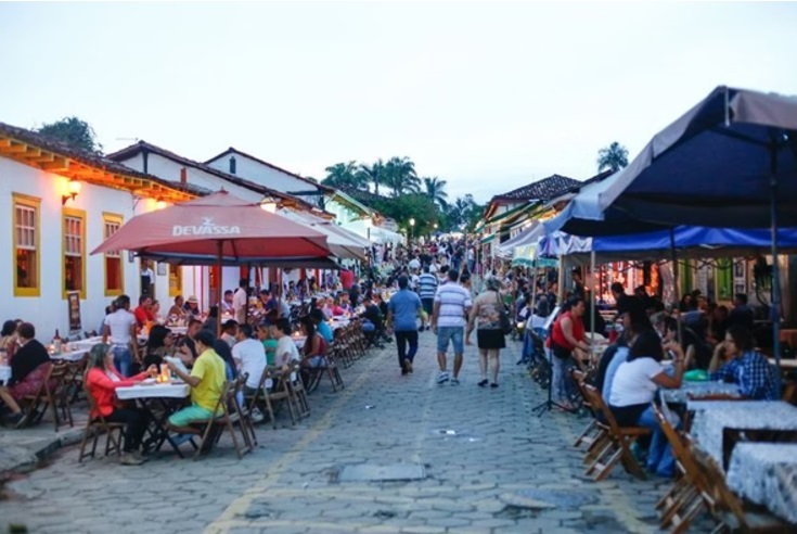 Rua do Lazer - Pessoas andando, bares e mesas com guarda sol, na rua - Pirenópolis - GO