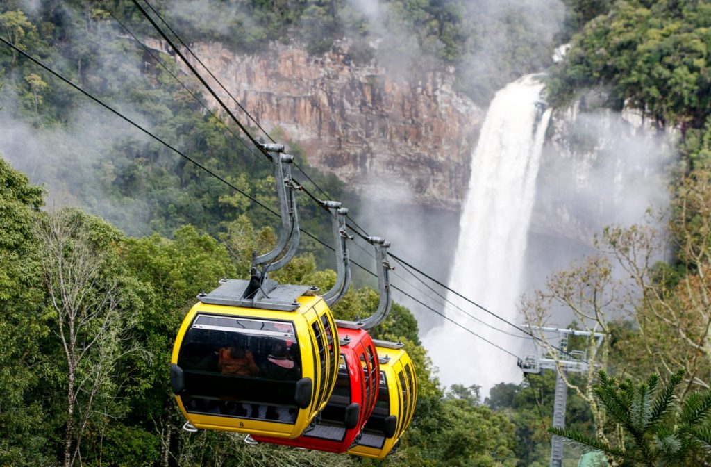 Bondinhos com cachoeira de fundo. Parque das Serras em Gramado, Rio Grande do Sul