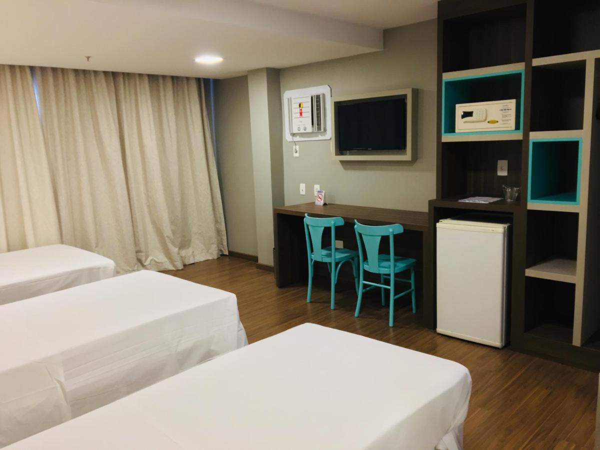 Quarto com três camas, mesa e cadeiras, televisão, frigobar - Master Express Cidade Baixa, Porto Alegre