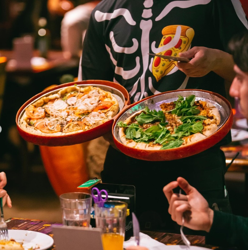 Duas pizzas e garçom do Toca da Bruxa Cristal, POrto Alegre