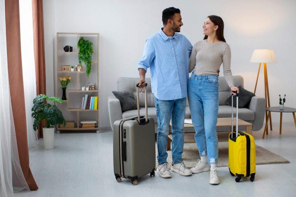 Casal com malas em uma sala de estar.