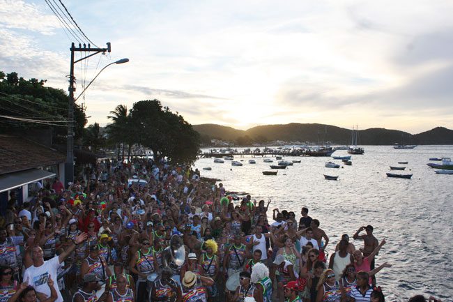 Carnaval em Búzios: orla BArdot cheia de foliões e barcos no mar ao fundo