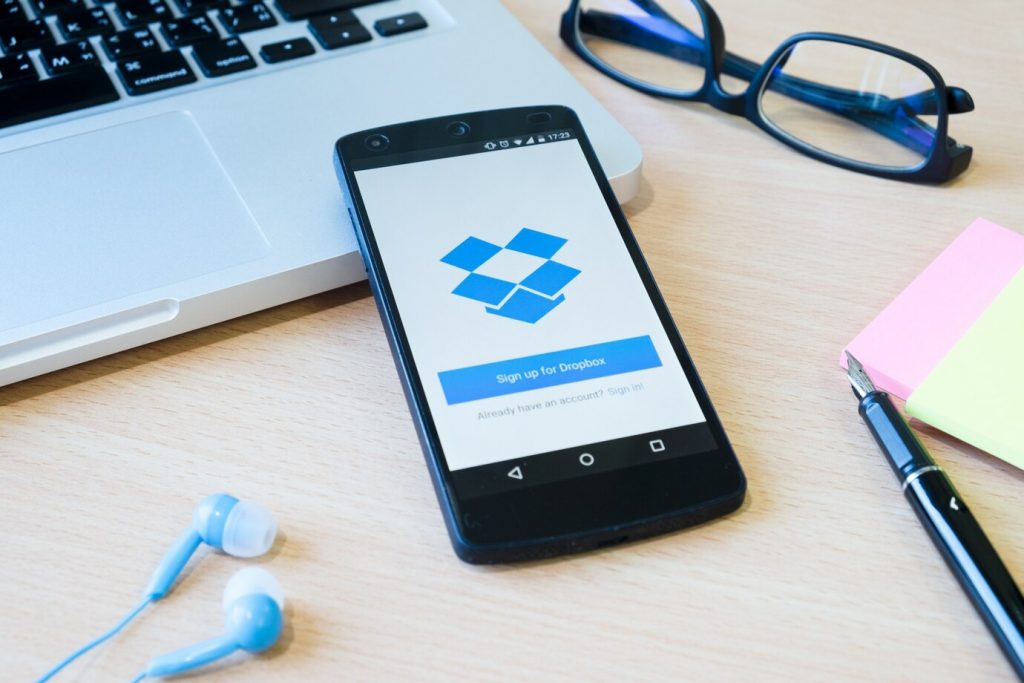 Dropbox - na tela de celular e um notebook.