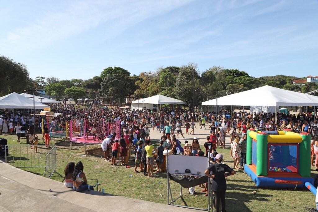 Muita gente e brinquedos infláveis em uma praça - Festa do Dia da Criança - Búzios