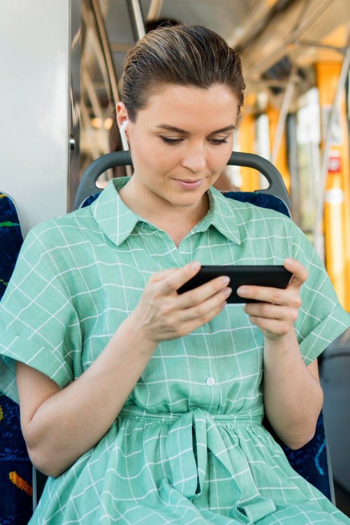 Pessoa em ônibus com celular na mão 