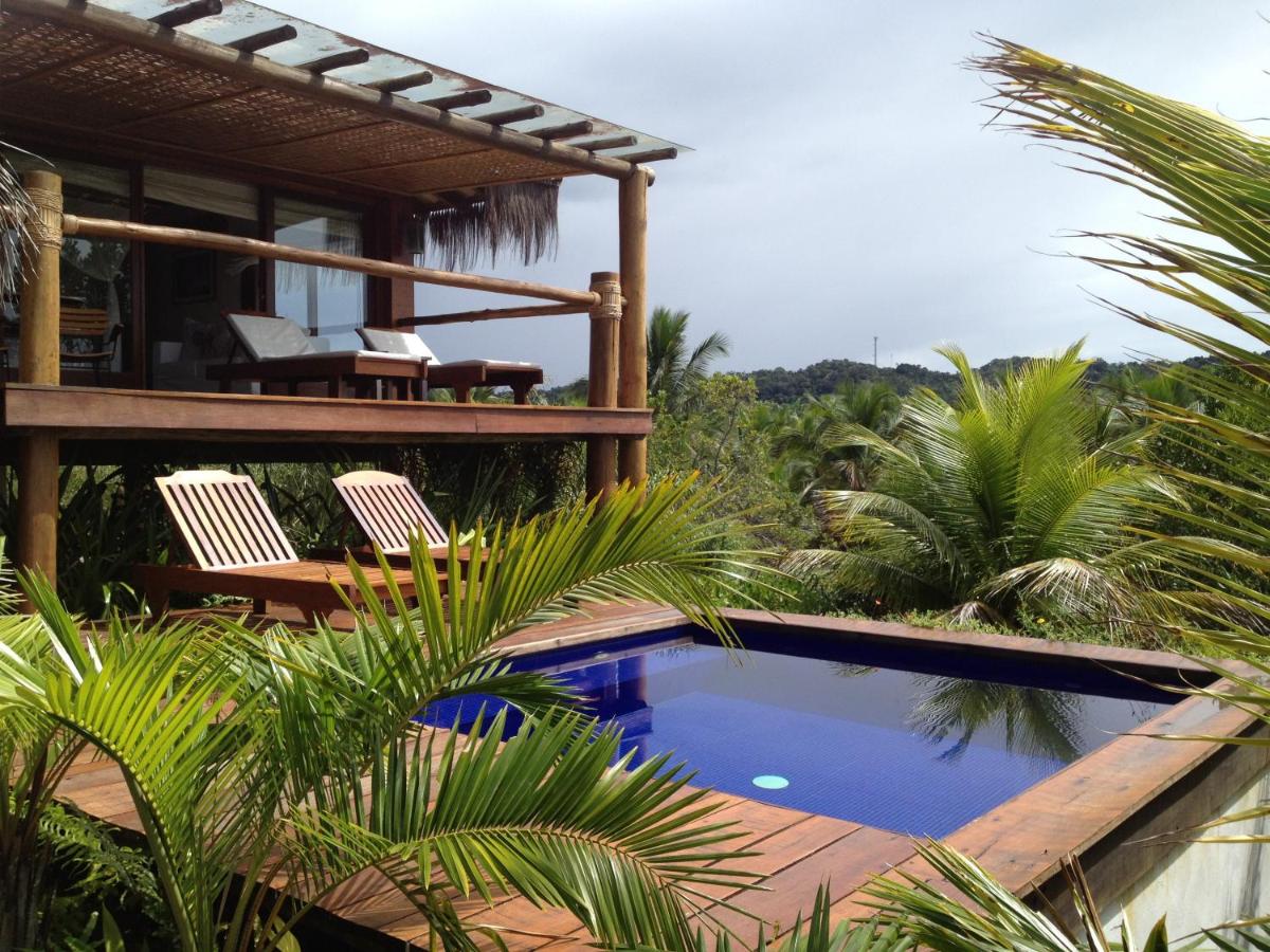 Vista da piscina, varanda e espreguiçadeiras do Txai Resort